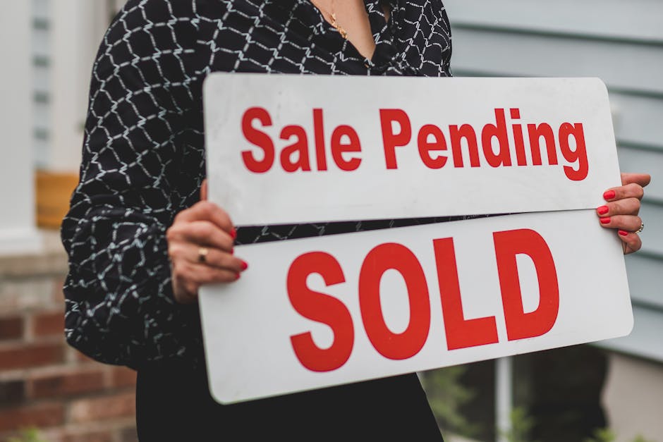 A businesswoman holding 'Sale Pending' and 'Sold' signs indicating a successful real estate transaction