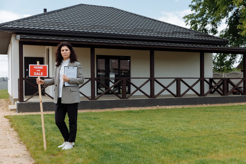 Real estate agent standing outside a house with a 'Home for Sale' sign on a grassy lawn